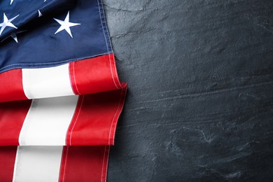 Photo of National flag of America on black table, top view. Space for text