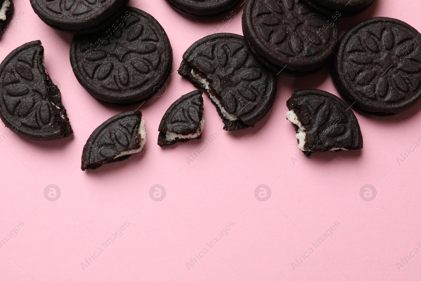 Photo of Tasty sweet sandwich cookies on pink background, flat lay. Space for text