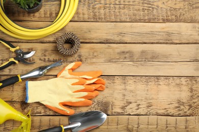 Flat lay composition with gardening tools on wooden background, space for text