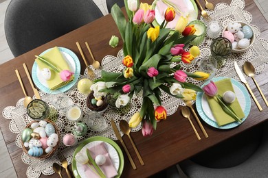 Festive table setting with beautiful flowers, top view. Easter celebration