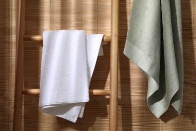 Photo of Soft terry towels and wooden ladder indoors