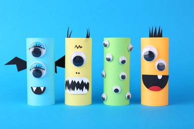 Photo of Spooky paper monsters on light blue background. Halloween decoration