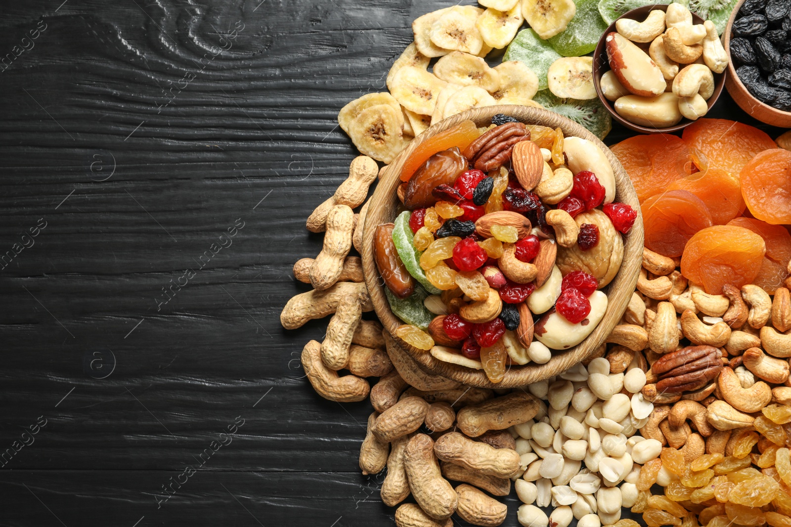 Photo of Flat lay composition of different dried fruits and nuts on color wooden background. Space for text