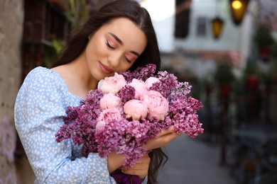 Photo of Beautiful woman with bouquet of spring flowers outdoors, space for text