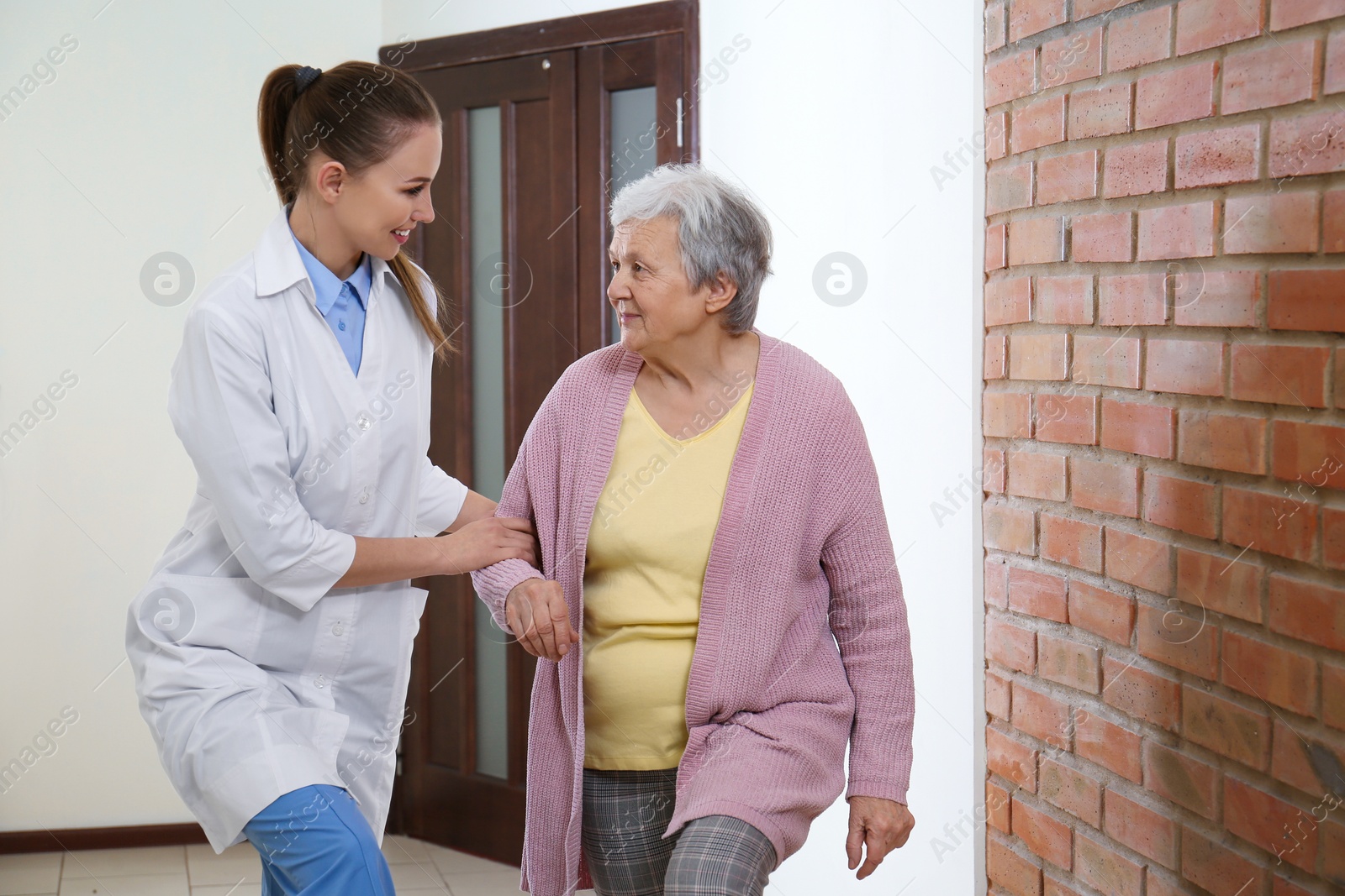 Photo of Doctor helping senior patient at modern clinic