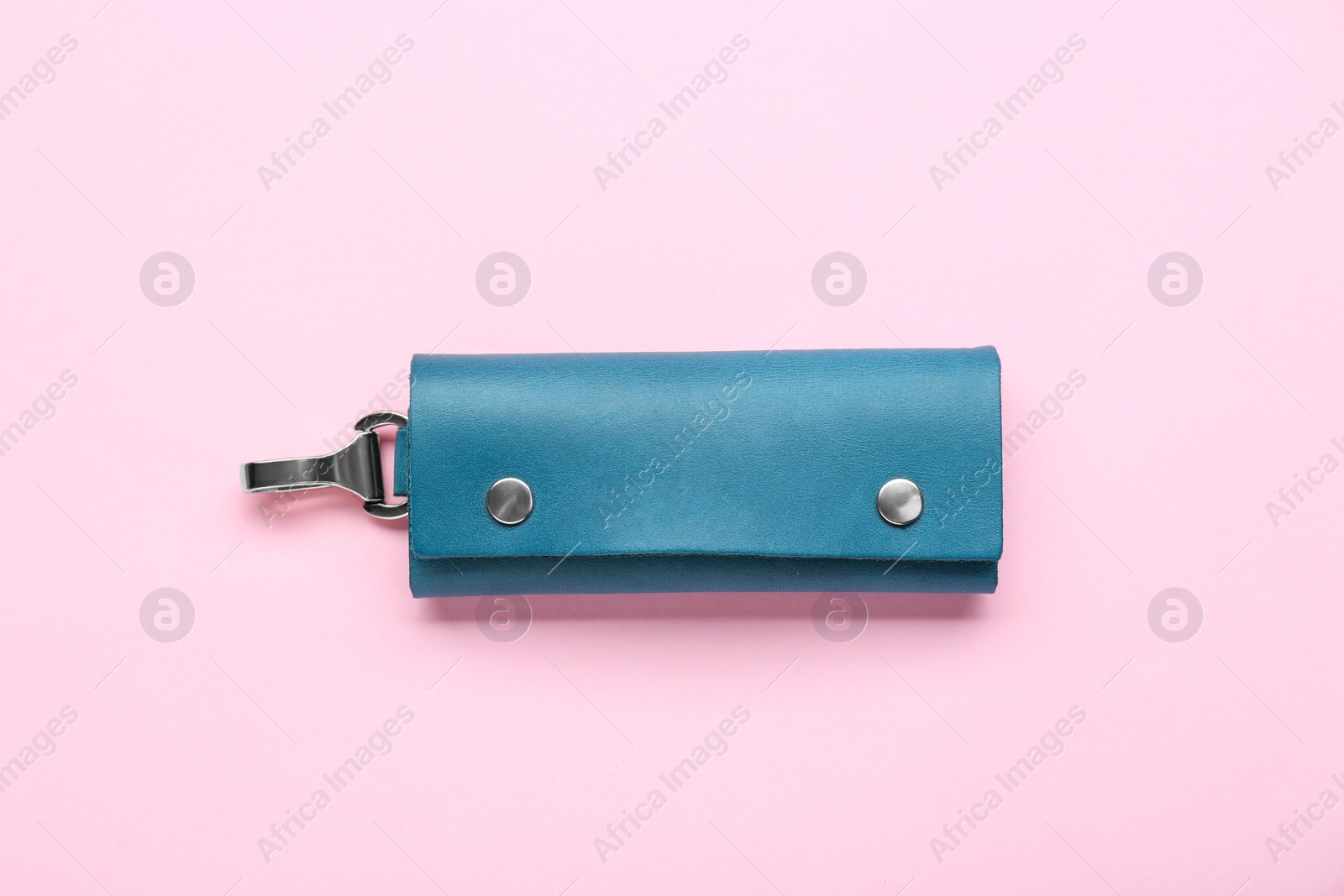 Photo of Stylish leather keys holder on pink background, top view