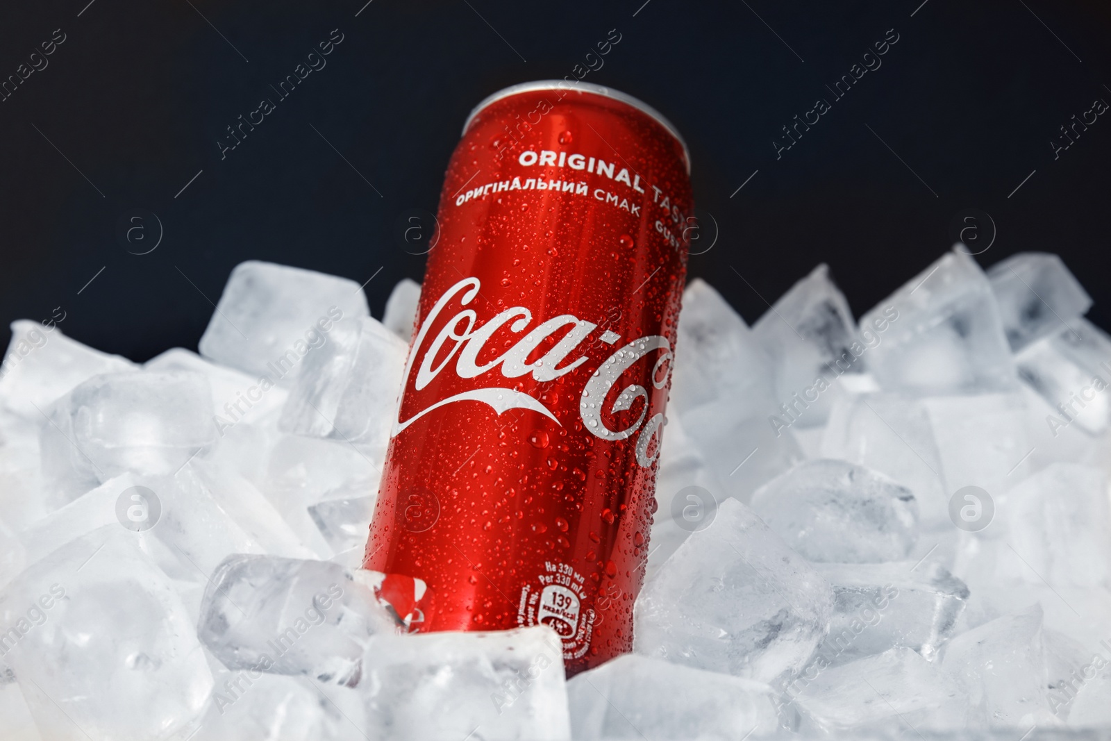 Photo of MYKOLAIV, UKRAINE - NOVEMBER 15, 2018: Coca Cola can on ice cubes against black background