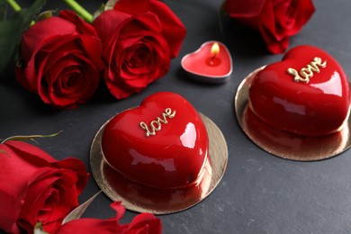 Photo of St. Valentine's Day. Delicious heart shaped cakes, roses and candle on black table