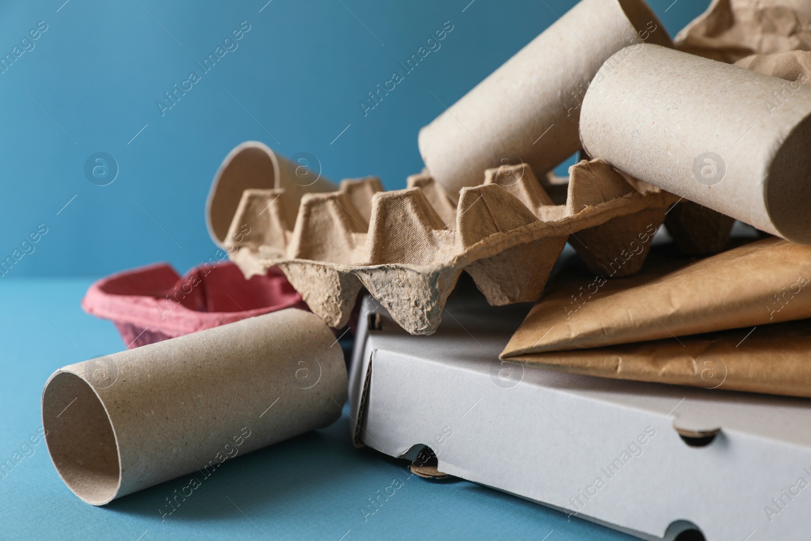 Photo of Different waste paper on light blue background, closeup