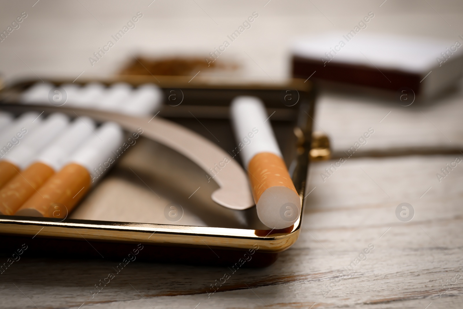 Photo of Stylish case with cigarettes on white wooden table, closeup