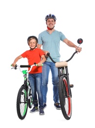 Photo of Portrait of father and his son with bicycles on white background