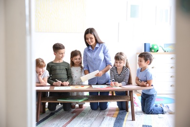 Cute little children with teacher in classroom at school