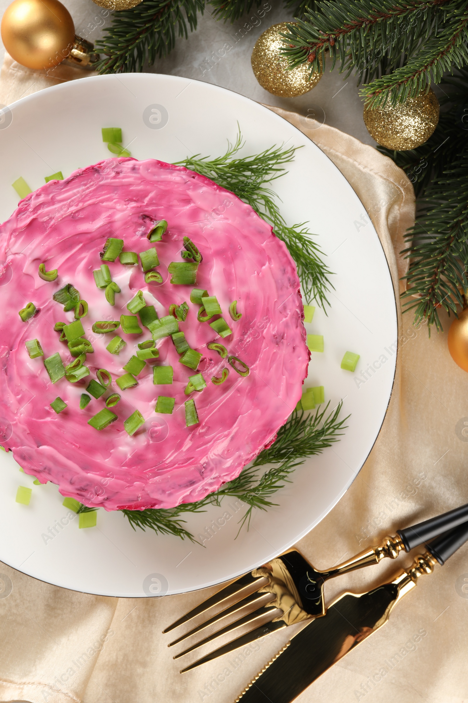 Photo of Herring under fur coat salad and Christmas decor on light grey table, flat lay. Traditional Russian dish