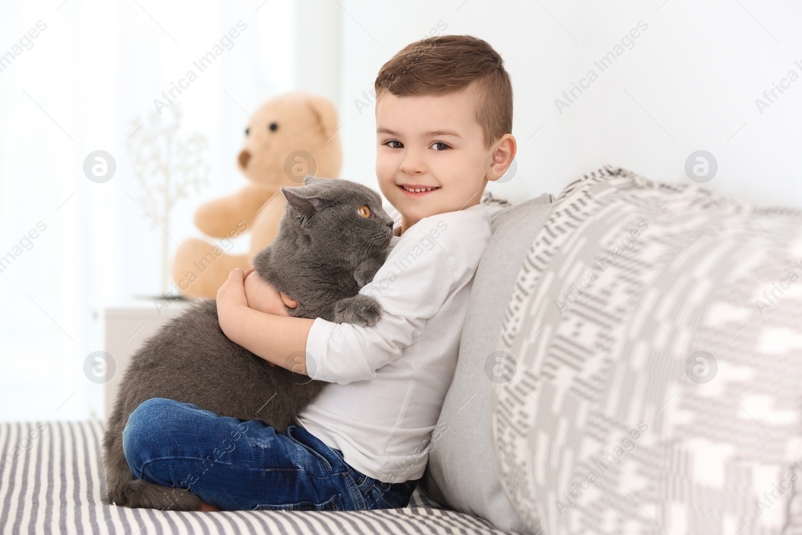 Photo of Cute little child with cat at home