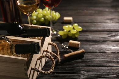 Photo of Crates with bottles of wine on wooden table