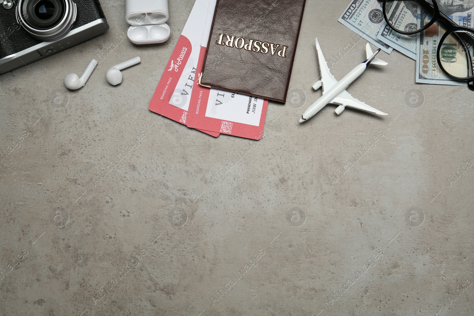 Photo of Flat lay composition with passport, toy plane and camera on grey table, space for text. Visa receiving