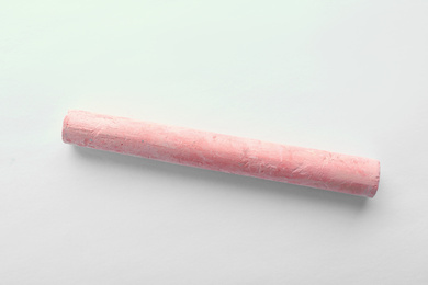 Photo of Piece of pink chalk isolated on white, top view