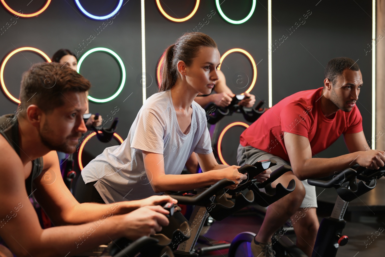 Photo of Group of people training on exercise bikes in fitness club