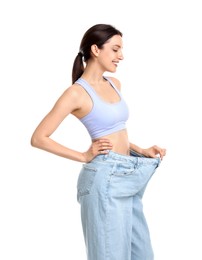 Photo of Happy young woman in big jeans showing her slim body on white background