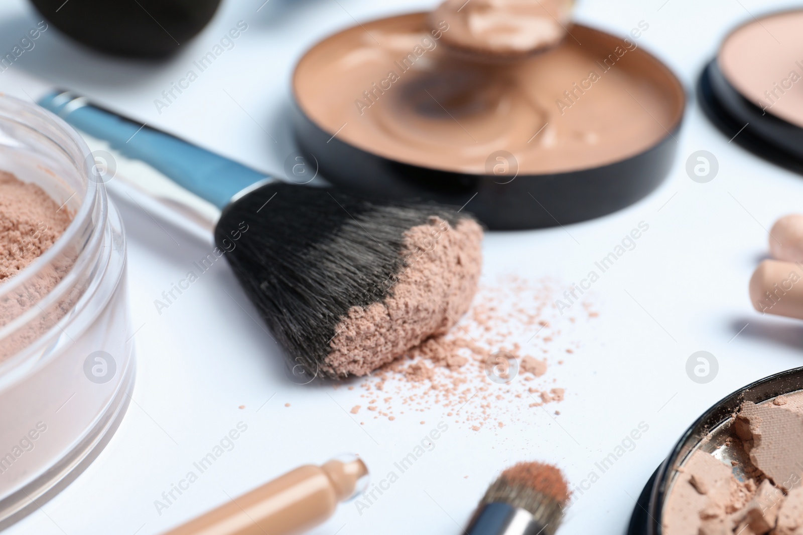 Photo of Composition with powder, skin foundation and beauty accessories on white background