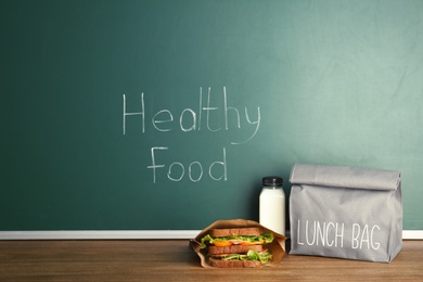 Lunch for school child on table near chalkboard with written Healthy Food