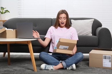 Photo of Emotional woman unpacking parcel at home. Online store