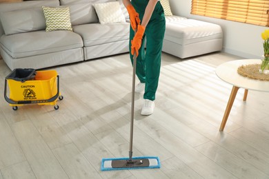 Woman cleaning floor with mop at home, closeup