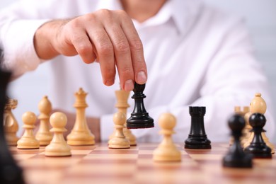 Man moving chess piece at checkerboard, closeup