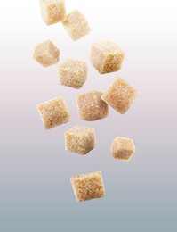 Image of Brown cane sugar cubes falling on grey gradient background