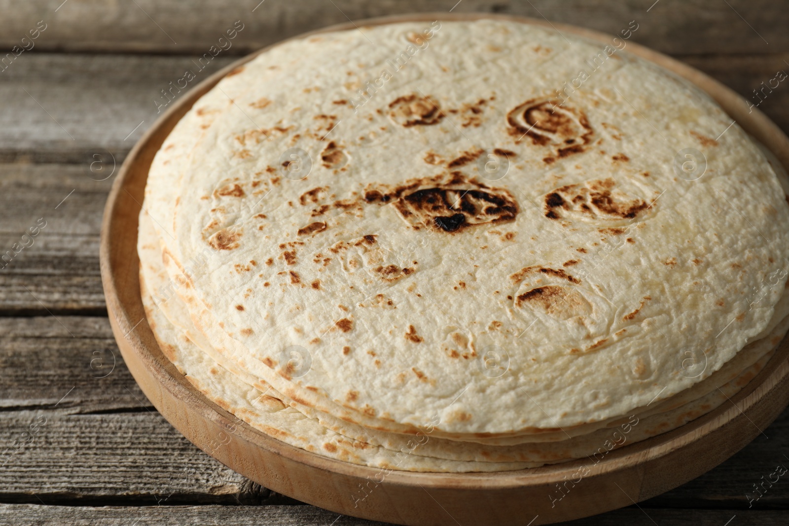 Photo of Stack of tasty homemade tortillas on wooden table
