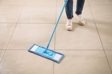 Photo of Woman cleaning floor with mop, closeup view