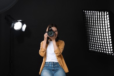 Photo of Professional photographer taking picture in modern photo studio