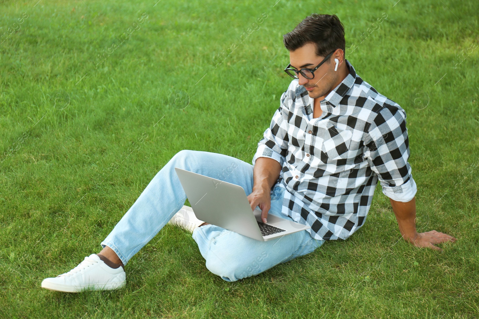 Photo of Portrait of young man with laptop outdoors