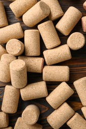 Photo of Many corks of wine bottles on wooden table, flat lay