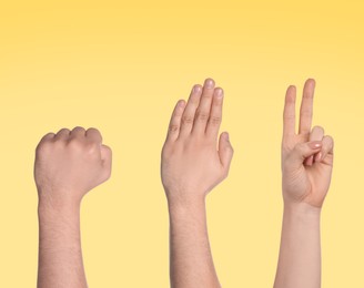 People playing rock, paper and scissors on yellow background, closeup