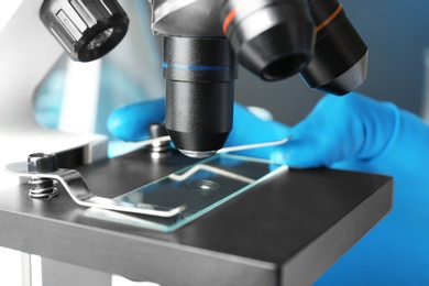 Photo of Scientist working with modern microscope, closeup. Chemical research