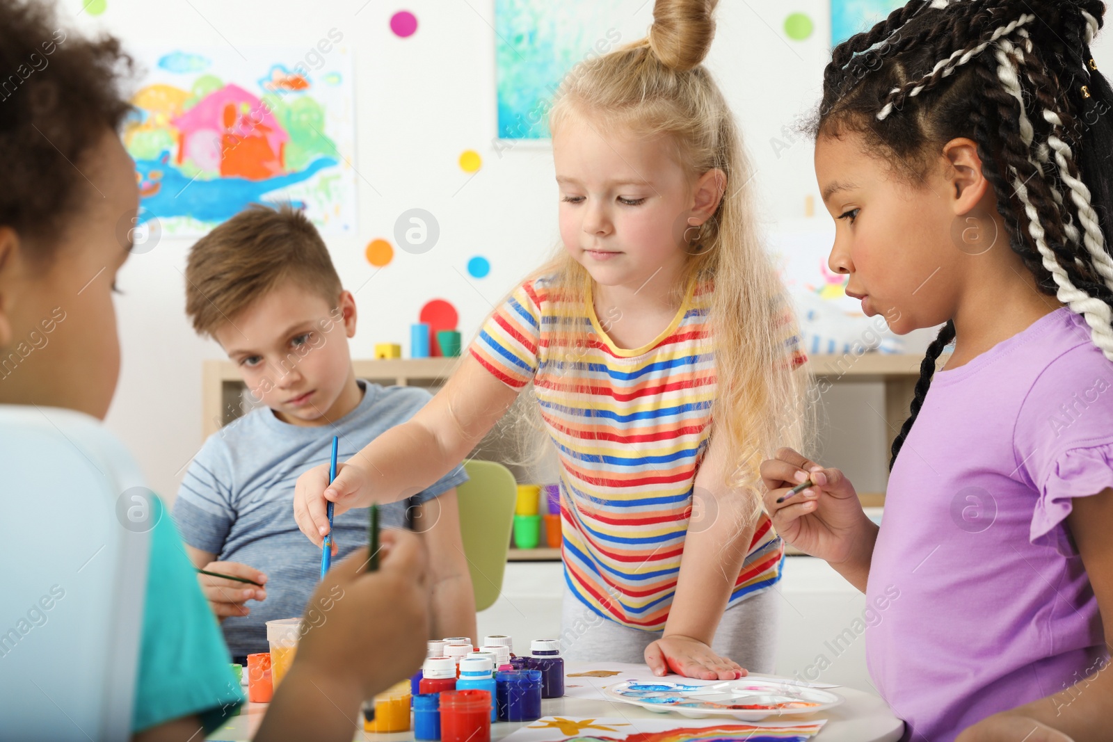 Photo of Cute little children painting at lesson indoors