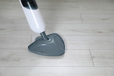 Photo of Cleaning floor with steam mop at home. Space for text