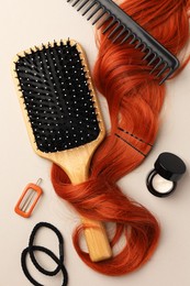 Photo of Wooden brush, comb and red hair strand on light background, flat lay