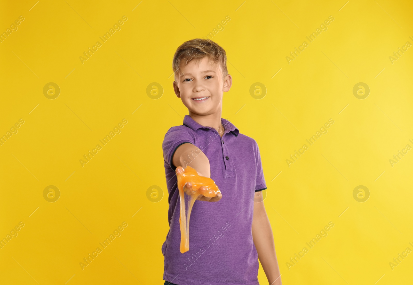 Photo of Preteen boy with slime on yellow background