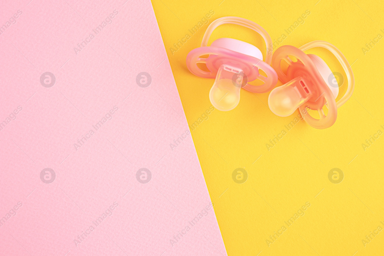 Photo of New baby pacifiers on color background, flat lay. Space for text