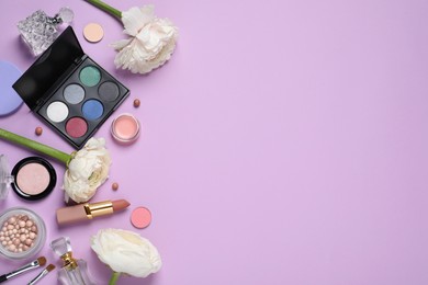 Photo of Flat lay composition with different makeup products and beautiful flowers on violet background, space for text