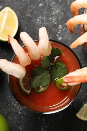 Photo of Tasty shrimp cocktail with sauce in glasses on grey textured table, flat lay