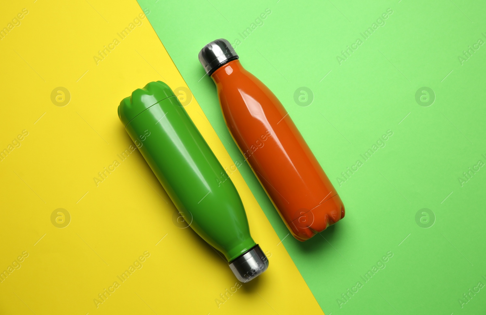 Photo of New modern thermo bottles on color background, flat lay