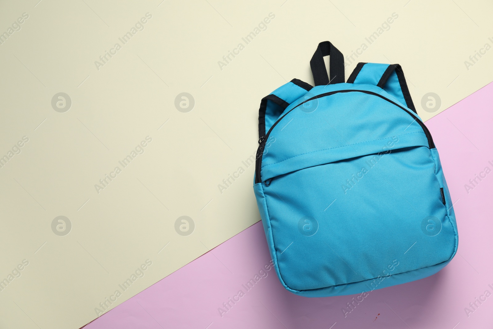 Photo of Stylish light blue backpack on color background, top view. Space for text