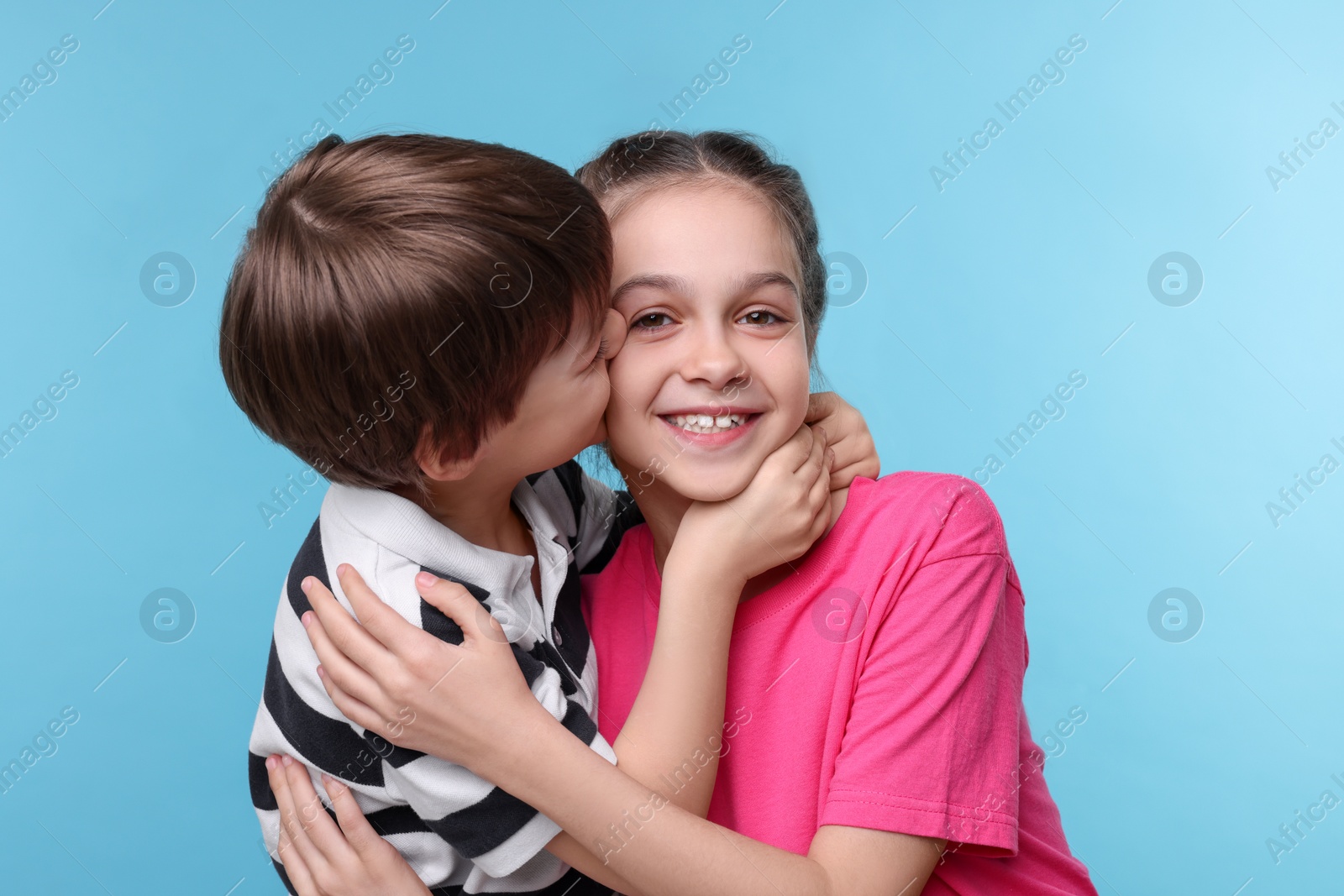 Photo of Happy brother and sister on light blue background