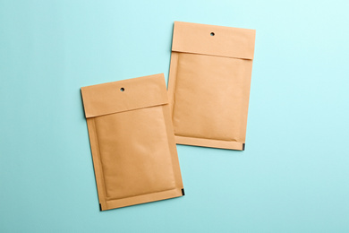 Photo of Kraft paper envelopes on light blue background, flat lay