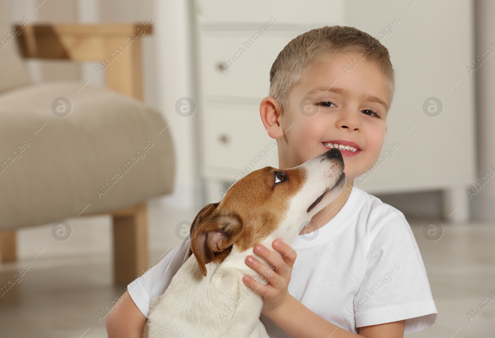 Photo of Little boy with his cute dog at home, space for text. Adorable pet