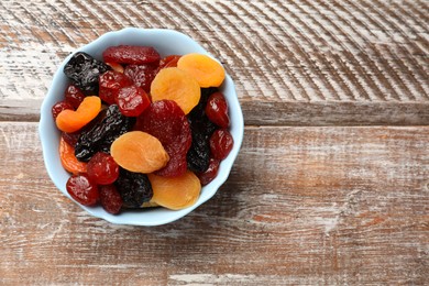 Photo of Mix of delicious dried fruits on wooden table, top view. Space for text