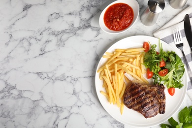 Flat lay composition with grilled beef steak on white marble table, space for text
